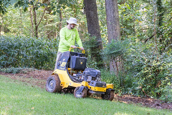 Photo of a Simply Green service manager using a core aerator on a customer lawn